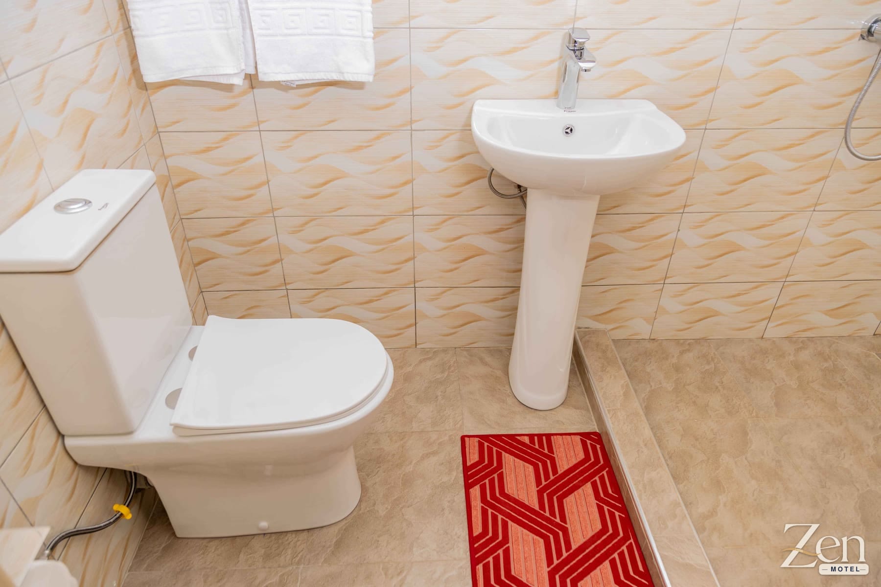 Private bathroom with fresh towels and a pedestal basin