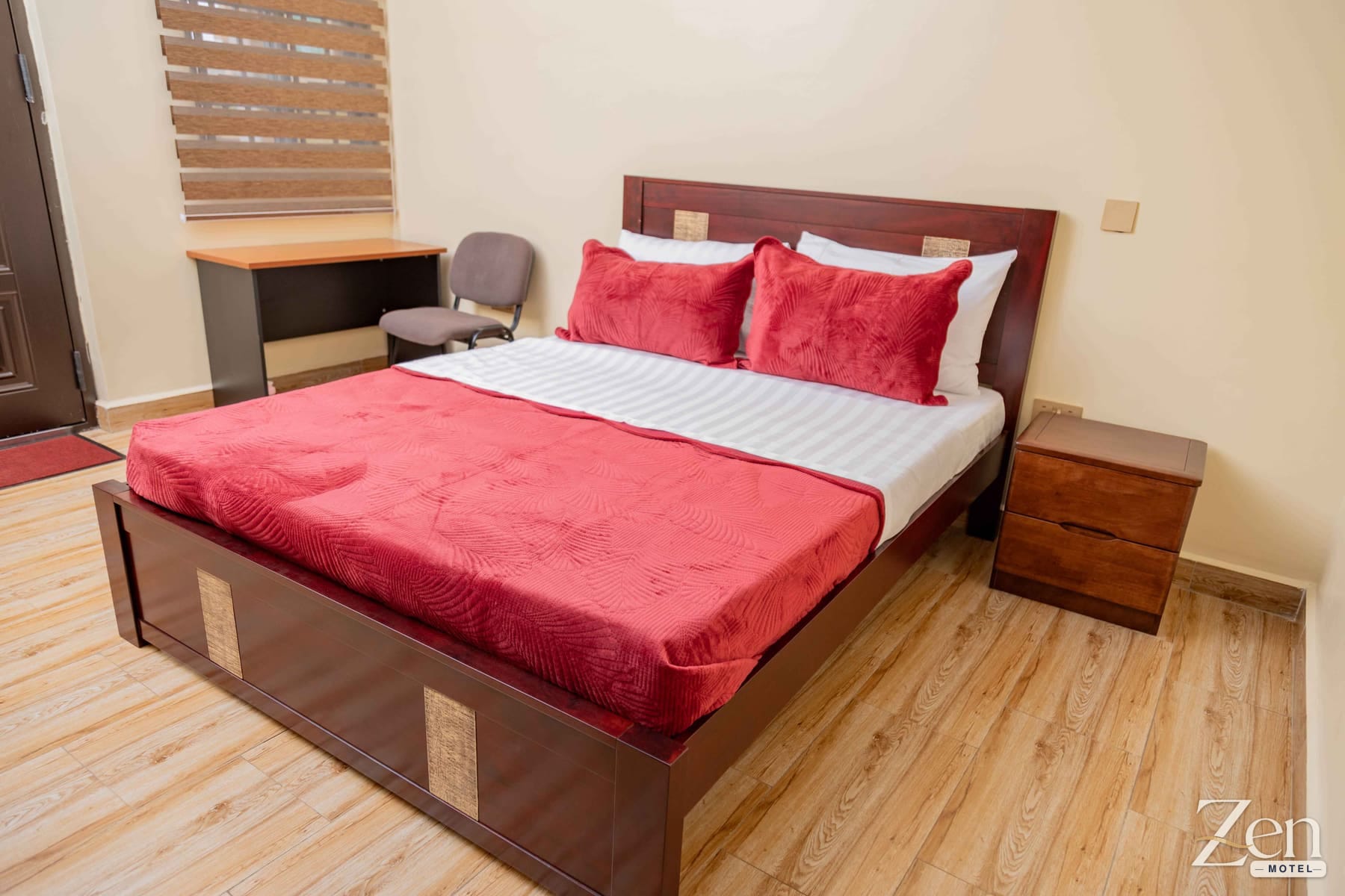 Deluxe Double Room showing the bed, bedside table and work desk by the window