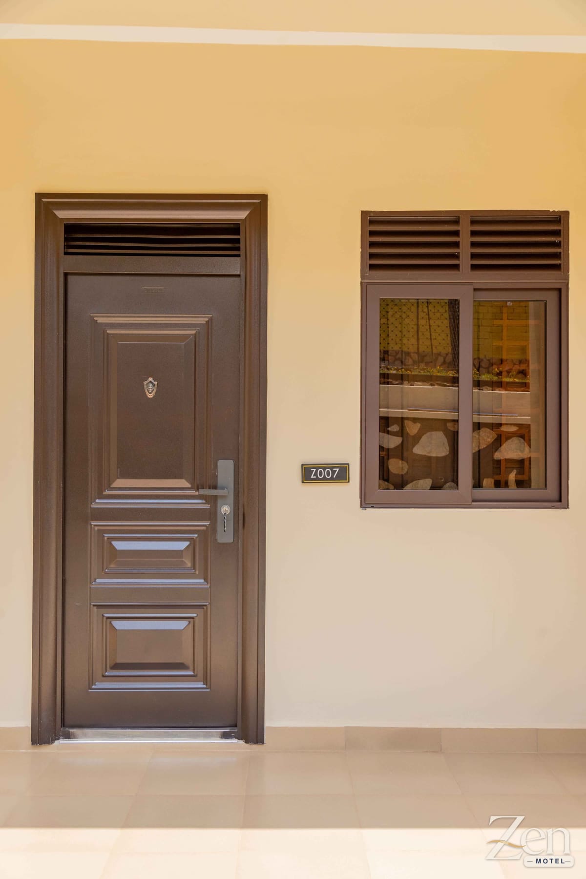 A guest room door and window off the covered walkway