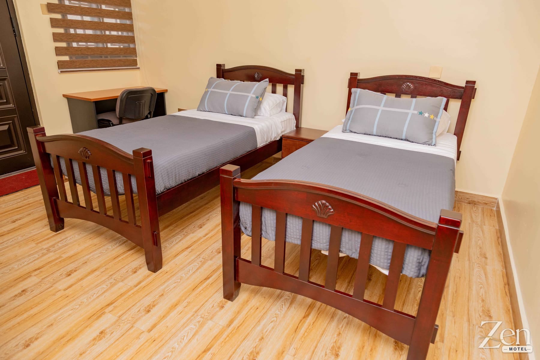 Room with two single beds and a work desk